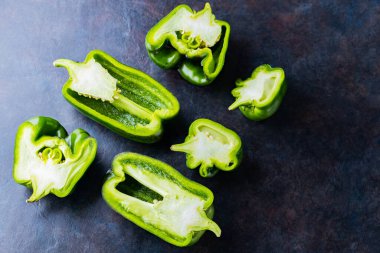 Karanlık arka planda çirkin dolmalık biber. Masada dilimlenmiş dolmalık biber parçaları var. Gıda organik atıklarının azaltılması kavramı. GDO olmayan sebzeler. Uzayı kopyala Üst görünüm