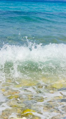 Deniz dalgası ve çakıl taşı. Yaz tatili kavramı. Kıyı şeridinde köpüklü deniz dalgası olayı. Seyahat kavramı