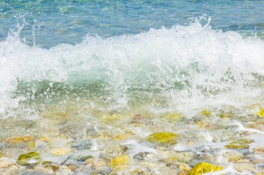 Deniz dalgası ve çakıl taşı. Yaz tatili kavramı. Kıyı şeridinde köpüklü deniz dalgası olayı. Seyahat kavramı