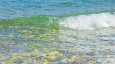 Deniz dalgası ve çakıl taşı. Yaz tatili kavramı. Köpüklü deniz dalgası. Seyahat kavramı