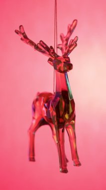 Geyik oyuncağı. Pembe arka planda kristal cam geyik. Holografik geyik. Şenlik konsepti. Dikey video