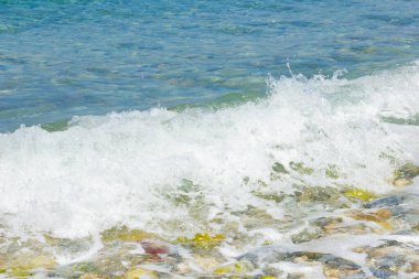 Deniz dalgası ve çakıl taşı. Yaz tatili kavramı. Kıyı şeridinde köpüklü deniz dalgası olayı. Seyahat kavramı