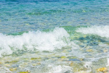 Deniz dalgası ve çakıl taşı. Yaz tatili kavramı. Kıyı şeridinde köpüklü deniz dalgası olayı. Seyahat kavramı