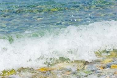 Deniz dalgası ve çakıl taşı. Yaz tatili kavramı. Kıyı şeridinde köpüklü deniz dalgası olayı. Seyahat kavramı