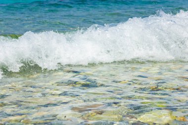 Deniz dalgası ve çakıl taşı. Yaz tatili kavramı. Kıyı şeridinde köpüklü deniz dalgası olayı. Seyahat kavramı