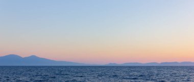 Sis ve dağlarla kaplı bir deniz manzarası. Gün batımında deniz manzarası. Denizden dağlara kadar sisli bir manzara. Dramatik sahneler ve doğanın güzelliği. Boşluğu kopyala