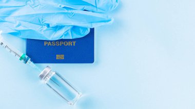 Aşı konsepti. Uluslararası biyometrik aşı pasaportu, aşı şişesi ve şırınga. Aşı şişesi, şırınga ve mavi arka planda pasaport. Dokunulmazlık pasaportu