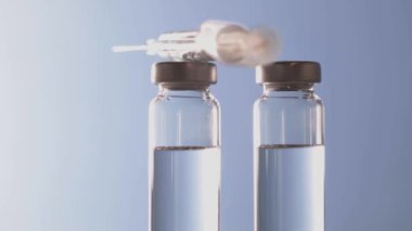 Aşı şişeleri kapanıyor. Aşı şişesi cam şişeleri tıbbi laboratuarda dönüyor. İlaç endüstrisi.