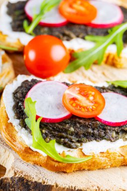 Avokado kremalı vejetaryen sandviçler. Krem peynir, avokado, turp ve vişneli domatesli sağlıklı sandviçler. Yakın plan.