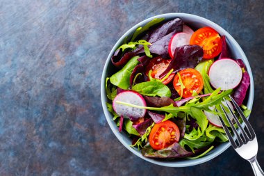 Sağlıklı salata, yapraklar karışık salata. Kiraz domatesli vejetaryen salatası, turp ve karışık salata. Keto ya da paleo diyeti konsepti. Uzayı kopyala Üst görünüm