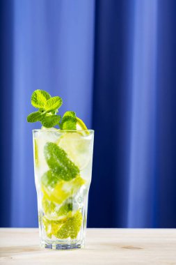 Ahşap arka planda mojito kokteyli. Uzun bardakta yaz mojito kokteyli. Limonlu, naneli ve buzlu içecek. Moda içeceği