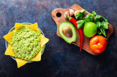 Malzemeli guacamole ve nachos tortilla cipsi. Arka planda biber, limon ve mısır cipsli avokado sosu. Uzayı kopyala Üst görünüm