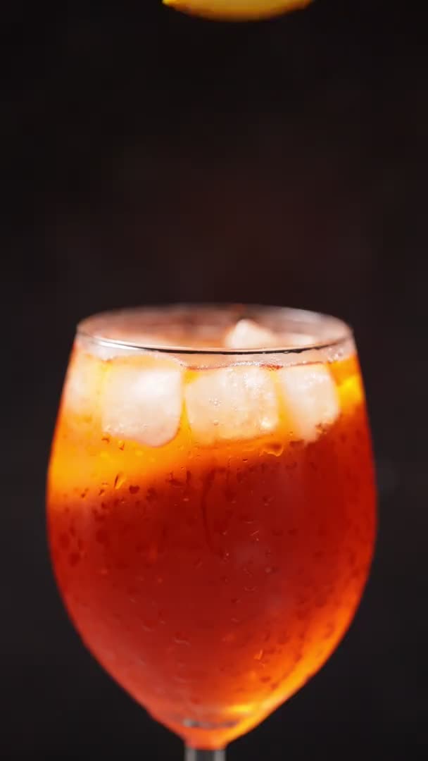 Barman Dodaje Kawałek Pomarańczy Koktajlu Koktajl Aperol Spritz Czarnym Tle — Wideo stockowe