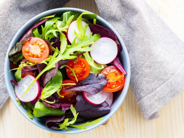 Kiraz domatesli sağlıklı salata, turp ve karışık salata. Ahşap arka planda yeşillik karışımı salata. Boşluğu kopyala