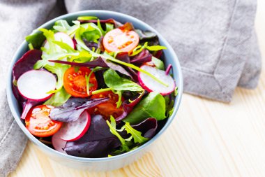 Kiraz domatesli sağlıklı salata, turp ve karışık salata. Ahşap arka planda yeşillik karışımı salata. Boşluğu kopyala