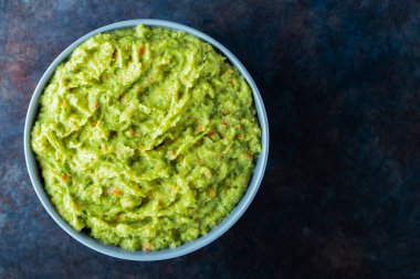 Arka planda gri bir kasede guacamole. Bir kase avokado guacamole sosu ve taze malzemeler. Uzayı kopyala Üst görünüm