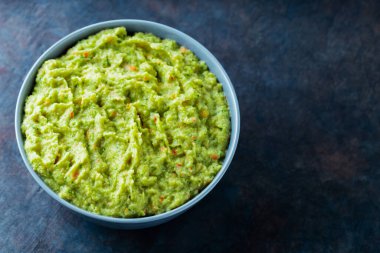 Arka planda gri bir kasede guacamole. Bir kase avokado guacamole sosu ve taze malzemeler. Uzayı kopyala Üst görünüm