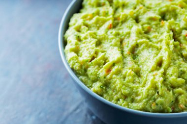 Arka planda gri bir kasede guacamole. Bir kase avokado guacamole sosu ve taze malzemeler. Uzayı kopyala Üst görünüm