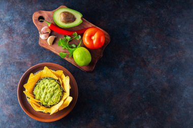 Malzemeli guacamole ve nachos tortilla cipsi. Arka planda biber, limon ve mısır cipsli avokado sosu. Uzayı kopyala Üst görünüm
