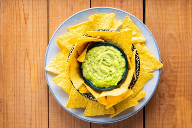 Tahta tahtalarda tortilla cipsi ile guacamole. Cips ve Meksika guacamole sosu tabakta. Uzayı kopyala Üst görünüm