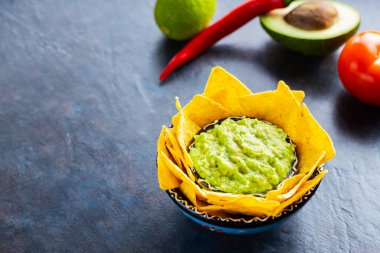 Avokado, biber, limon ve mısır cipsi karışımlı guacamole sosu. Malzemeli guacamole ve nachos tortilla cipsi. Boşluğu kopyala