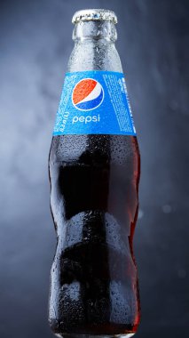 DNIPRO, UKRAINE - 15 Ağustos 2021: koyu arkaplanda cam şişe Pepsi. Popüler Amerikan içeceği.