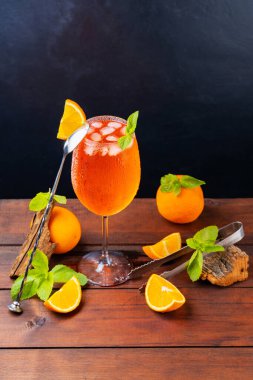 Kokteyl aperol spreyi ve bar aletleri. İtalyan aperol sprey kokteyli ve koyu arkaplanda dilimlenmiş portakal. Aperol sprey kokteyli ve taze nane.