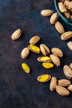 Koyu arkaplanda kavrulmuş fıstık. Pistachio - sağlıklı vejetaryen protein besleyici gıdalar. Sağlıklı atıştırmalıklar. Uzayı kopyala Üst görünüm