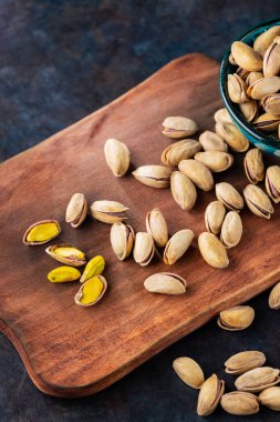 Kavrulmuş fıstıklı fıstık. Ahşap zeminde kızartılmış ve tuzlu şam fıstığı. Yakın plan.