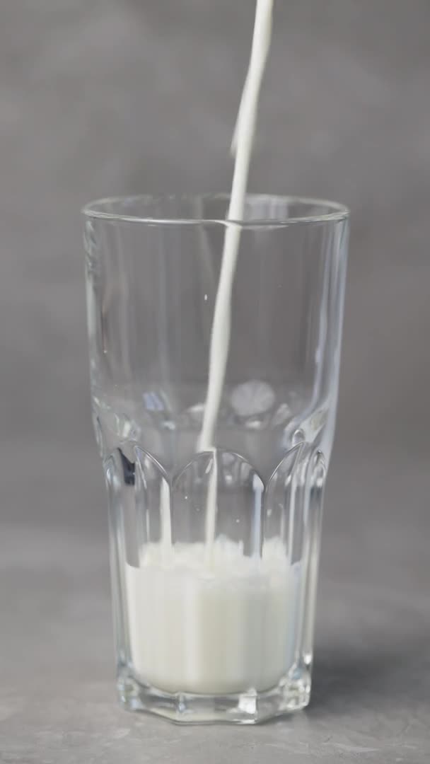 Melk Wordt Een Grijze Achtergrond Een Glas Gegoten Zuivelproductconcept Verticale — Stockvideo