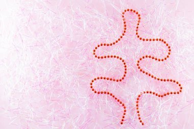 Sembol Noel 'i ve Noel ağacının süslenmiş kırmızı boncuklarıyla mutlu noeller. Pembe süslemeli Noel boncukları. Tatil konsepti. Üst görünüm