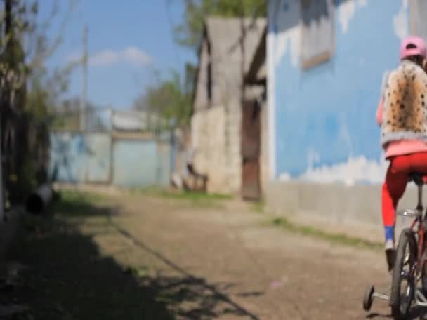 Chica montando una bicicleta en el patio Clip De Vídeo