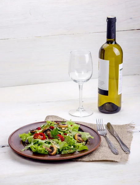 Vinho branco com salada vegetal de verdes, cogumelos e tomates com tempero — Fotografia de Stock