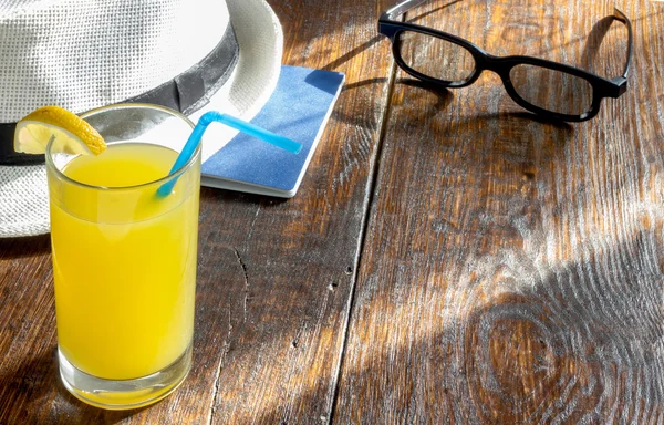 Glass of  juice with a summer hat and sunglasses — Stock Photo, Image