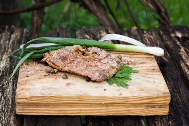 bir ahşap tahta üzerinde otlar ile biftek