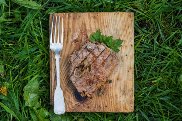 Bife com ervas em uma tábua de madeira — Fotografia de Stock