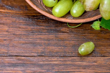 Ahşap bir masada yeşil üzümler