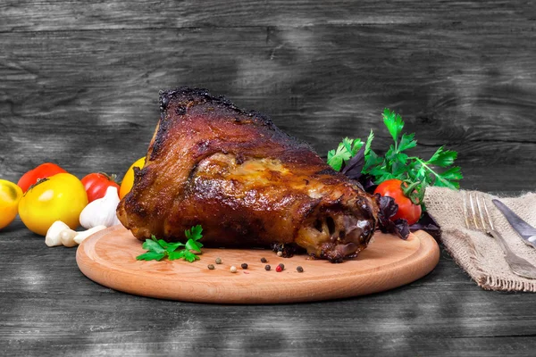 Shin, knee wild boar - roast pork leg with vegetables on black background — Stock Photo, Image