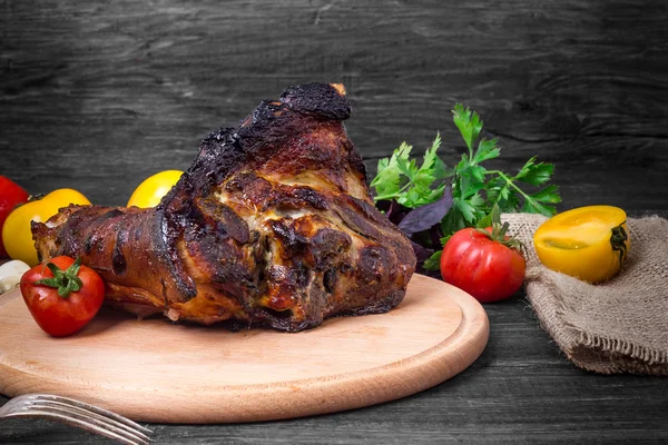 Shin, knee wild boar - roast pork leg with vegetables on black background — Stock Photo, Image