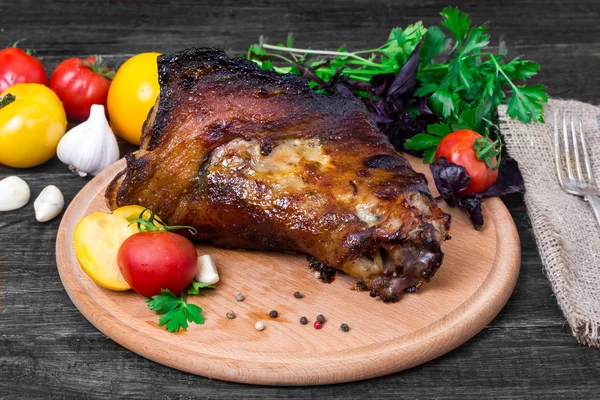 Schienbein, Knie Wildschwein - Schweinshaxe mit Gemüse auf schwarzem Hintergrund — Stockfoto