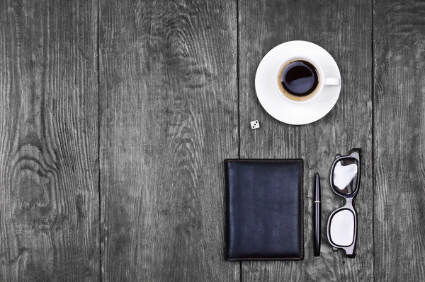 Masanın üzerine bir fincan kahve ve defter.
