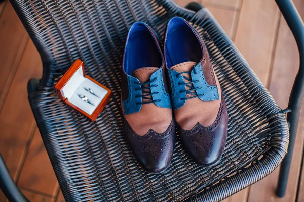 Zapatos azules y anillos de boda en la silla — Foto de Stock