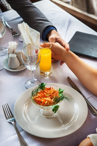 Manos de pareja romántica sobre una mesa de restaurante — Foto de Stock