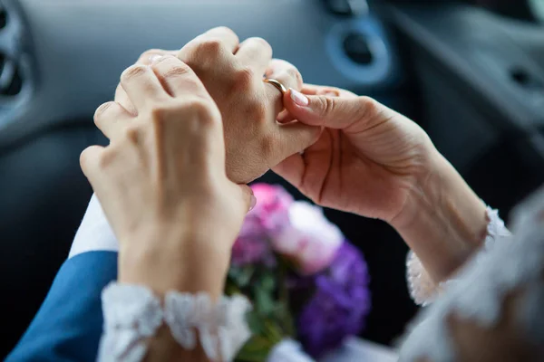 Jeune mariée a mis une bague de mariage en or sur le doigt des mariés, gros plan. — Photo