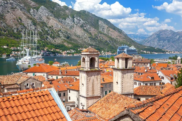 Zwei große weiße Touristenschiffe in der Bucht. Im Vordergrund steht eine Stadt an der Küste mit Ziegeldächern. kotor, montenegro — Stockfoto