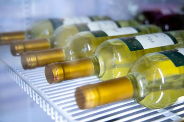 Rows of white wines on a shelf in a restaurant fridge, view through the glass: Russia. Moscow 20 December 2019