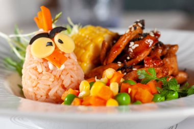 Restoranda çocuk menüsü var. Çocuklar için eğlenceli sağlıklı yiyecekler. pirinç eti ve sebzeler, parlak pişirilmiş.