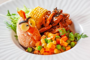 Restoranda çocuk menüsü servis ediliyor. Çocuklar için eğlenceli sağlıklı yiyecekler. pirinç eti ve sebzeler, parlak pişirilmiş.