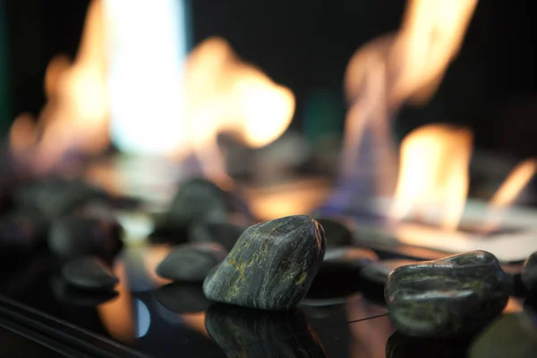 Bioethanol fueled portable fireplace burning at home, for live fire at home, no chimney and mantelpiece is needed. Liquid bio ethanol burns in cup. Round shaped glass with stones inside — Stock Image Bioethanol Fueled Portable Fireplace Burning Home Live Fire Home Chimney Stock Photo