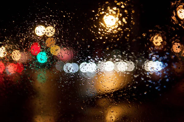 แสงไฟในเม องท านกระจกรถในสภาพอากาศท ฝนตก ตอนกลางค นหล งแบบนามธรรม หลายส — ภาพถ่ายสต็อก